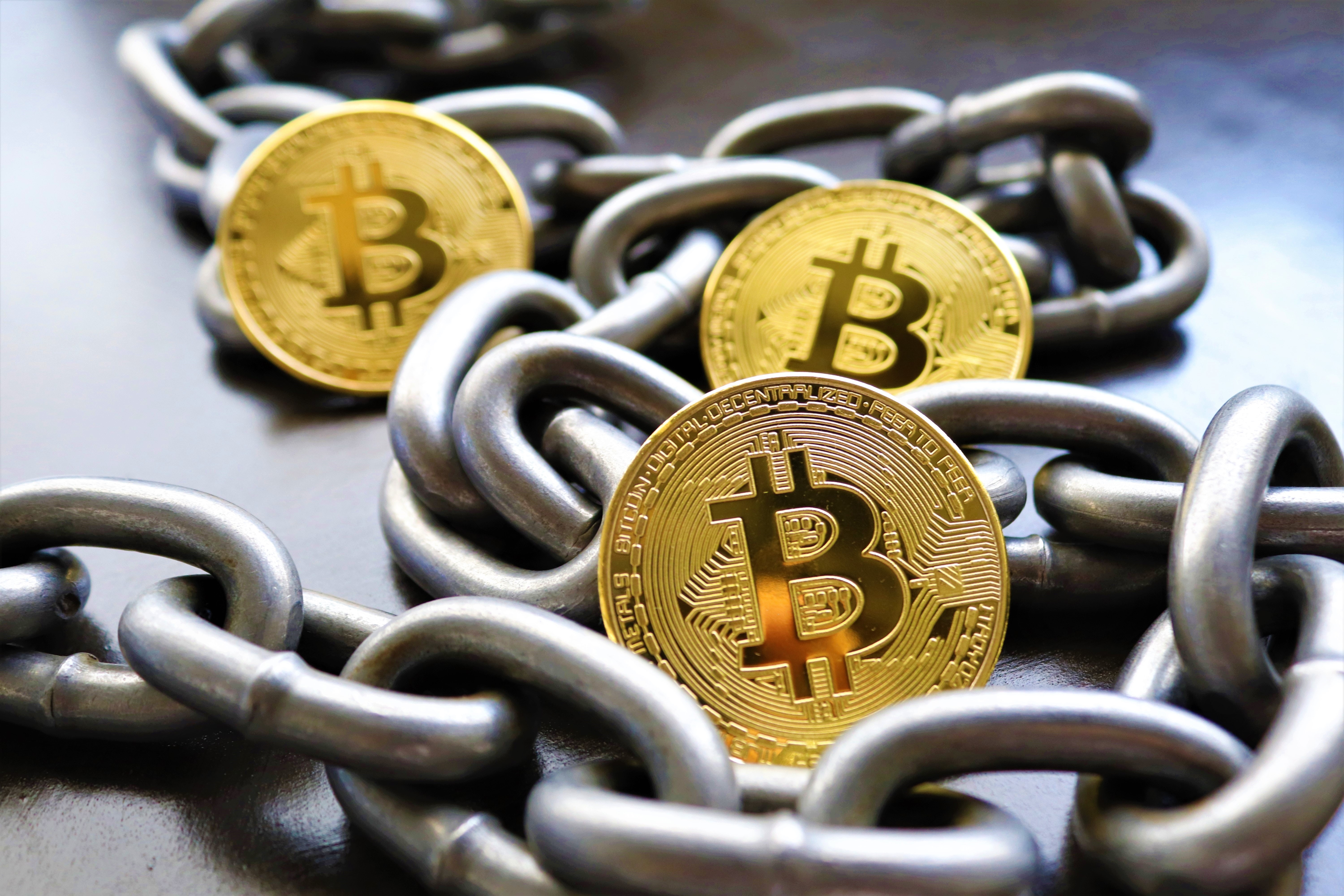 physical representation of bitcoins resting on a steel chain