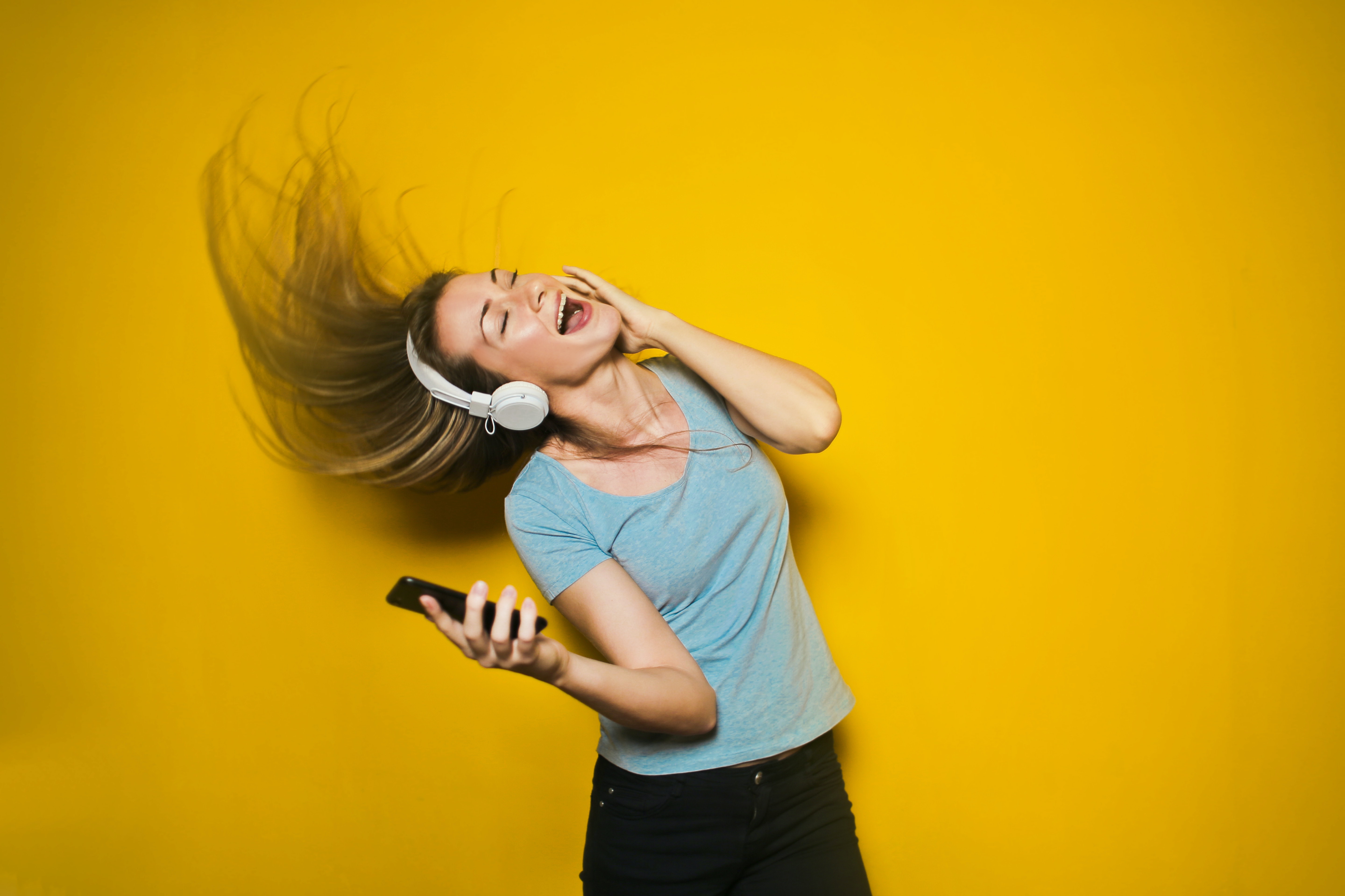 Cool and fun girl rocks out with headphones to music